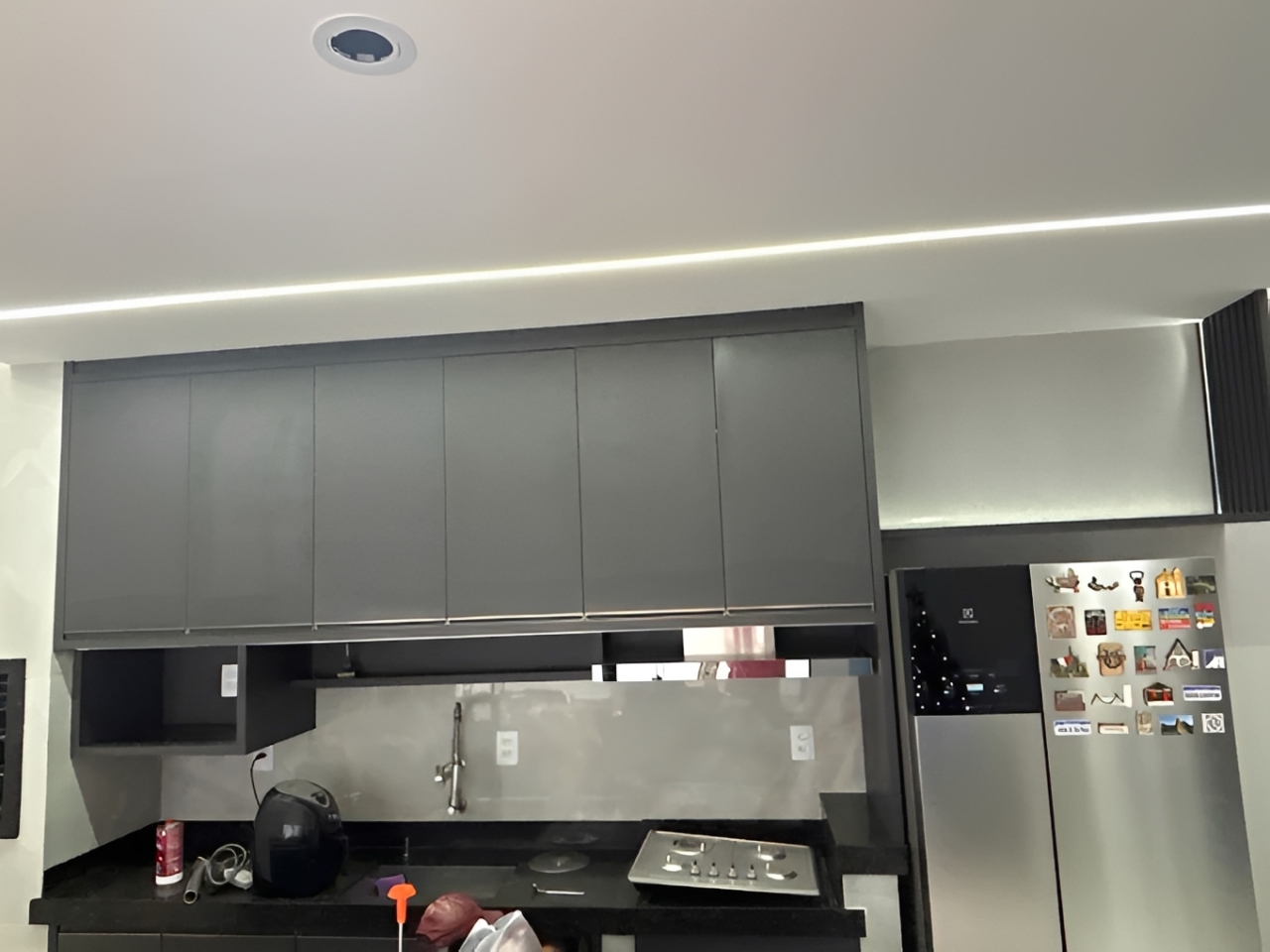 Cozinha planejada cinza com iluminação linear